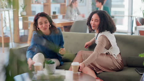 two women discussing business over coffee in a modern office