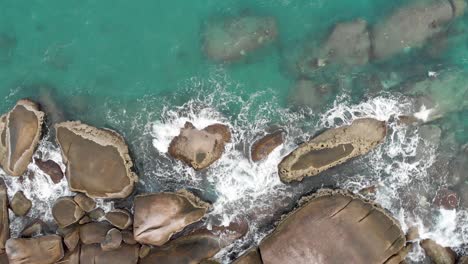 Vista-Aérea-De-Las-Olas-Del-Océano-Rompiendo-En-Las-Rocas