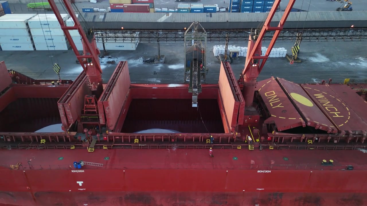 Drone shot moving out from showing salt inside cargo ship. Walvis Bay, Namibia