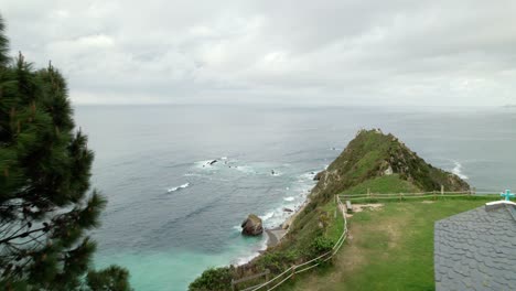 Aerial-dolly-shot-of-Ermita-de-la-Regalina,-a-small-chapel-on-a-cliff-on-the-Cantabrian-Sea,-in-the-province-of-Asturias-in-Spain