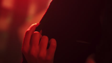 섹시한 분위기 속에서 그녀의 검은색 목욕 가운을 만지는 여성의 손의 영화적 장면