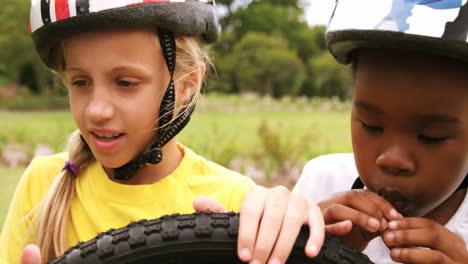 group of kids looking at bicycle wheel