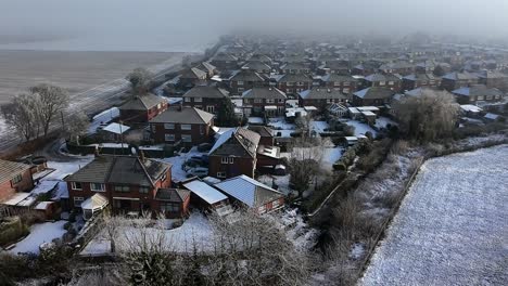 frosty morning mist aerial view descends across british small town neighbourhood houses and meadow