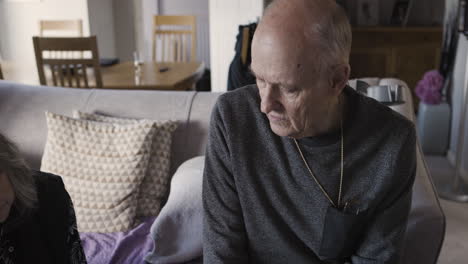 elderly man sitting on a couch in a living room