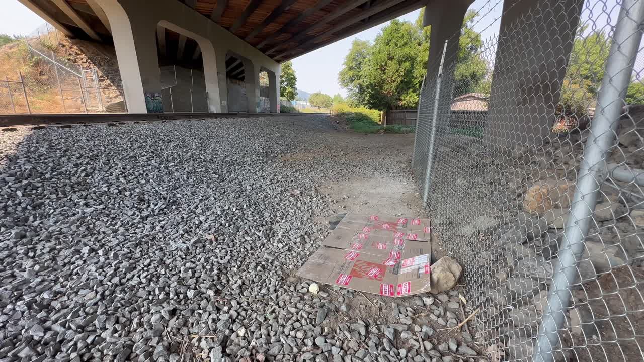 basura de cartón en la suciedad de un paso subterráneo y ferrocarril