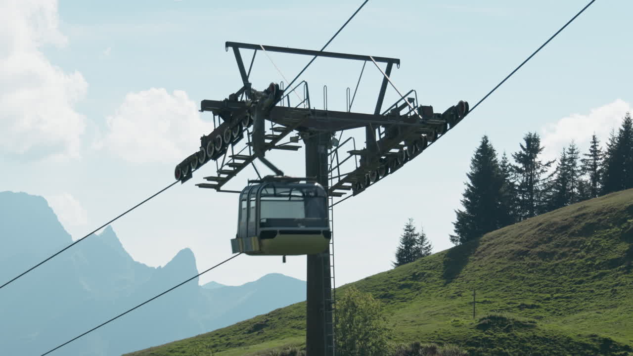 Static shot of an empty cable car passing a stabilizing pole in the evening with the sun low in the sky.