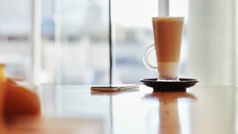 Glas-Kaffee-Und-Mobiltelefon-Auf-Dem-Tisch