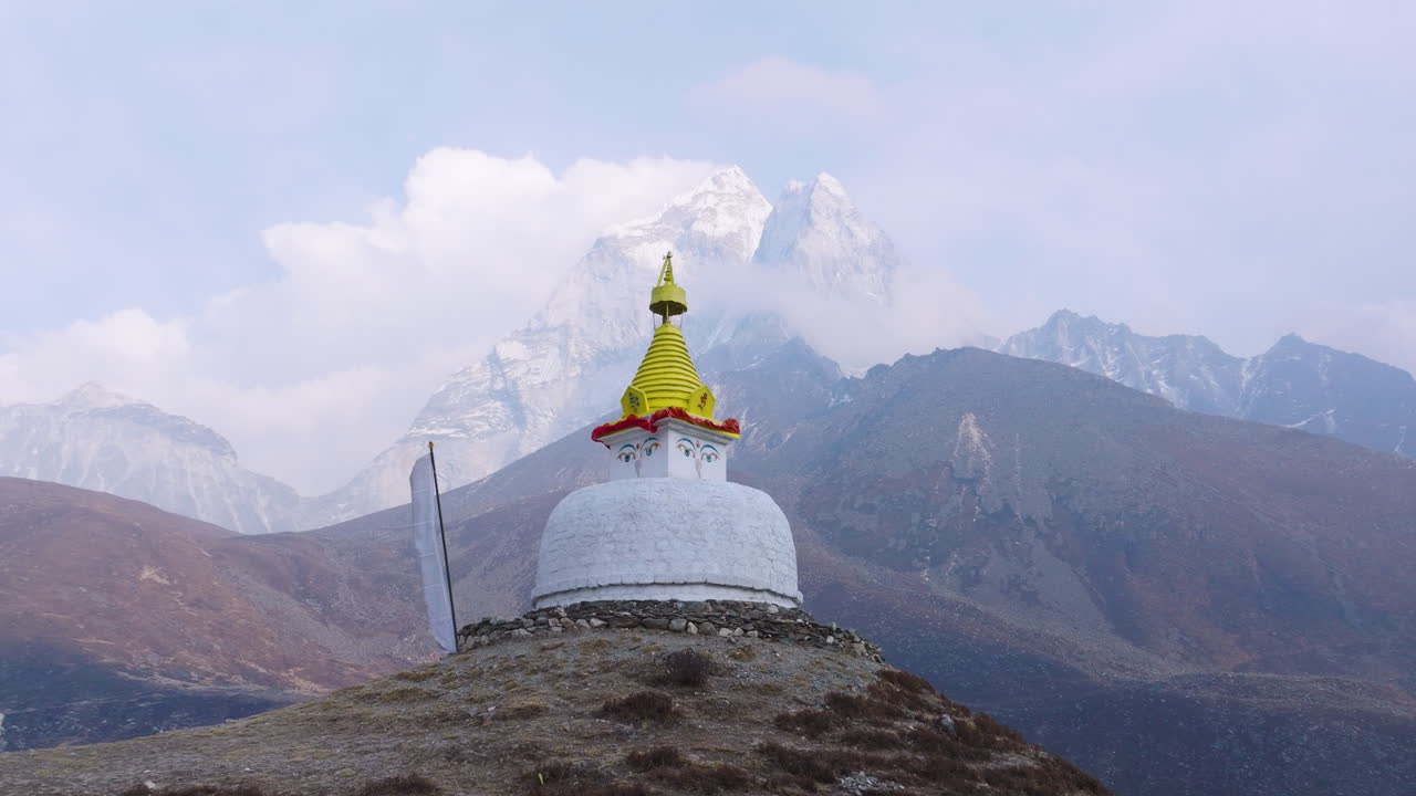 Drone view of Buddhist Stupa at Dingboche, 4400m. Flags flutter in gentle wind, majestic Himalayan backdrop, serene Everest Base Camp trek scenery enroute to experience tourism in Nepal