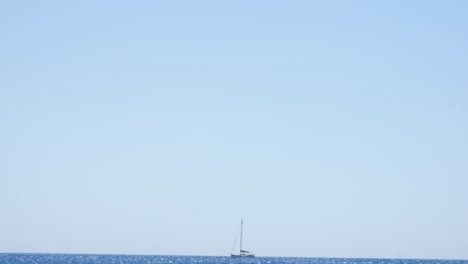 Sailboat-lost-and-alone-in-the-mediterranean-ocean-after-departing-Santorini-island-in-Greece