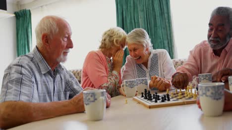 personas mayores activas de raza mixta jugando al ajedrez en el asilo de ancianos 4k