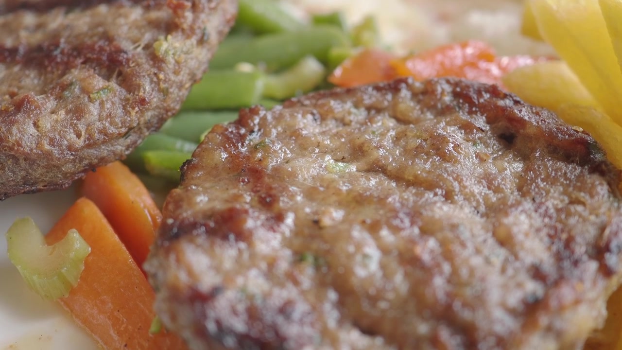 Close-up of Grilled Meat Patties Being Served on a Plate
