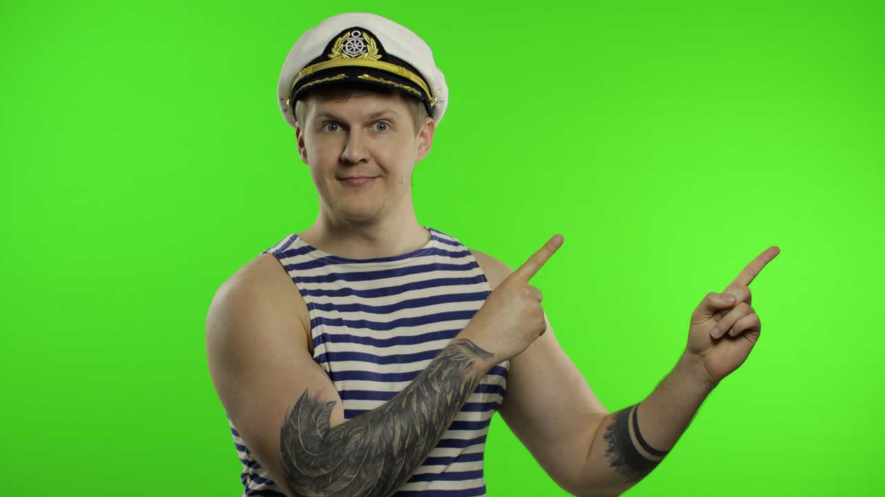 молодой моряк, указывающий на что-то руками.