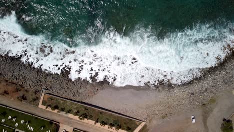 large waves rolling at the rocky beach on a windy day