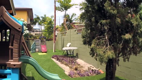 patio trasero suburbano con casa de juegos para niños en un día ventoso