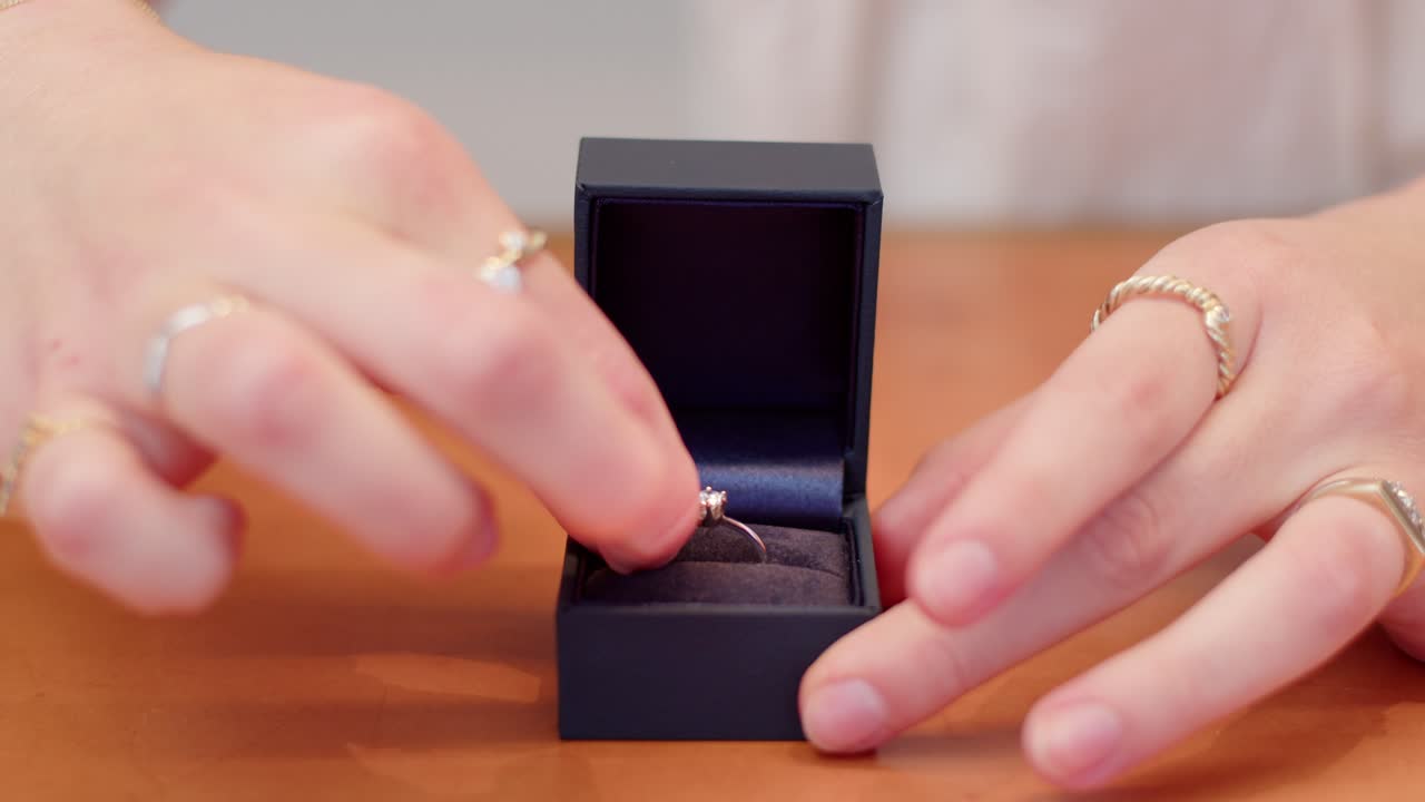 Diamond ring put in a box and closed by woman's hands