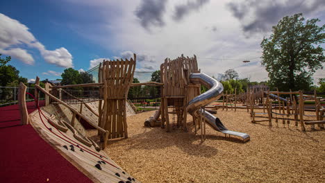 wooden playground equipment and structures in a public park on summer day