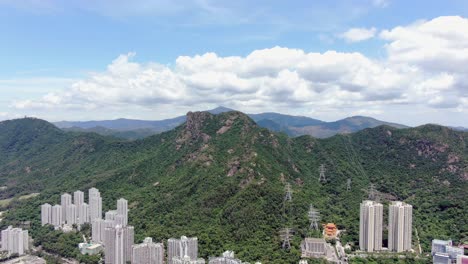 mega edificios residenciales en el centro de hong kong y lion rock mountain ridge en el fondo, vista aérea