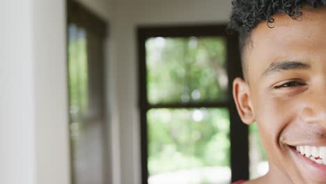 Portrait-of-happy-african-american-male-teenage-boy-at-home,-slow-motion