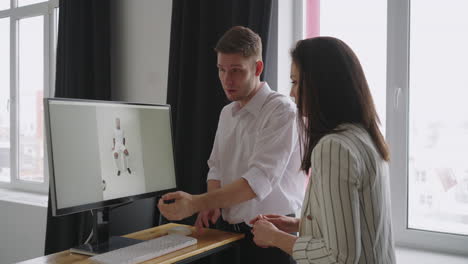 the designer art director producer are watching the photos on the computer monitor for a photo shoot discussing and choosing the best one for the magazine cover. discuss looking at the monitor