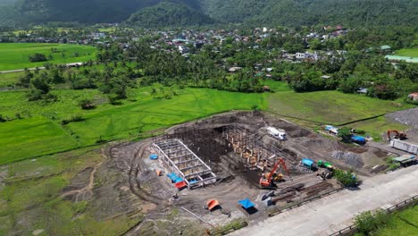 orbiting aerial drone shot of construction site at asian provincial countryside at malilipot, albay, philippines.