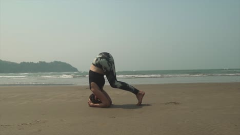 Mujeres-Controlando-Lentamente-Sus-Piernas-Desde-El-Suelo-Mientras-Hacen-Yoga-En-La-Playa