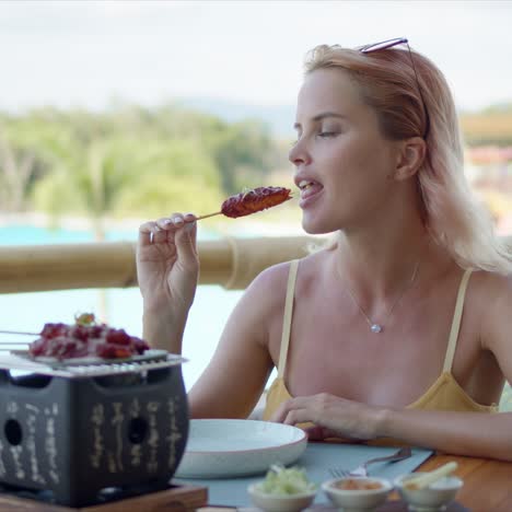 donna felice che mangia sulla terrazza del caffè