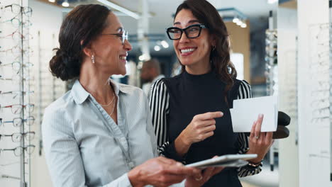 dos mujeres comprando gafas en una tienda óptica