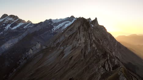 sobrevuelo aéreo sobre schaefler en appenzell, suiza al atardecer sobre un excursionista en la cresta