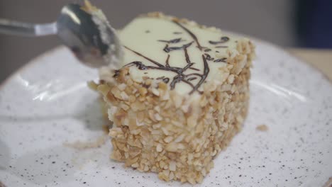 close up of a delicious piece of chocolate cake with nuts and white frosting