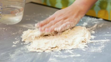 pouring water on dough