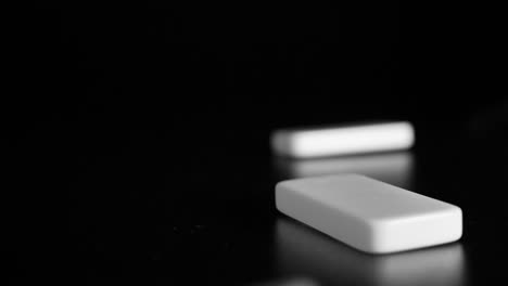 white domino dice fall on a black background