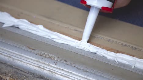 applying silicone sealant with a caulking gun - close up