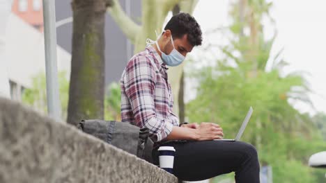 Kaukasischer-Mann,-Der-Eine-Coronavirus-Covid19-Maske-Trägt-Und-Seinen-Laptop-Benutzt