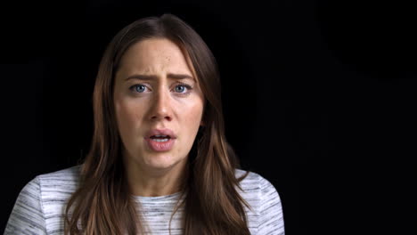 Studio-Shot-Of-Scared-Young-Woman-Flinching-From-Abuse