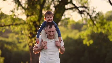 Papas-Hände-Halten-Einen-Kleinen,-Glücklich-Lächelnden,-Süßen-Sohn,-Der-Zusammen-In-Der-Natur-Spielt,-Auf-Dem-Land,-POV-Aufnahme,-Unbeschwerte-Familie,-Die-Das-Wochenende-Genießt,-Entspannt-Und-Eine-Schöne-Zeit-Im-Freien-Hat,-Aus-Der-Vogelperspektive.