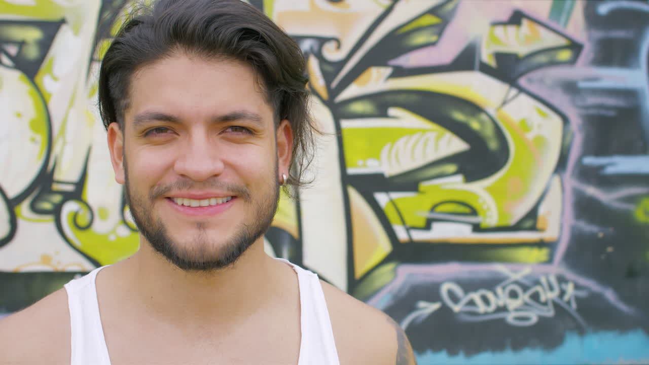 chico guapo bebiendo agua fresca de una botella de plástico en un parque de patinaje