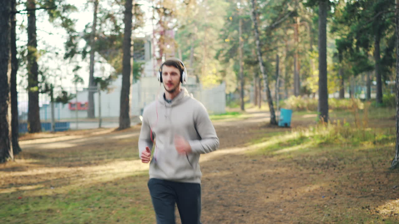 헤드폰을 들고 공원에서 달리는 남자