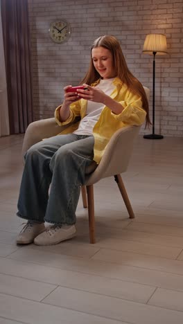 teenage girl using smartphone in chair