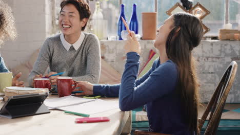 diverse group of students studying at home using books and laptop technology