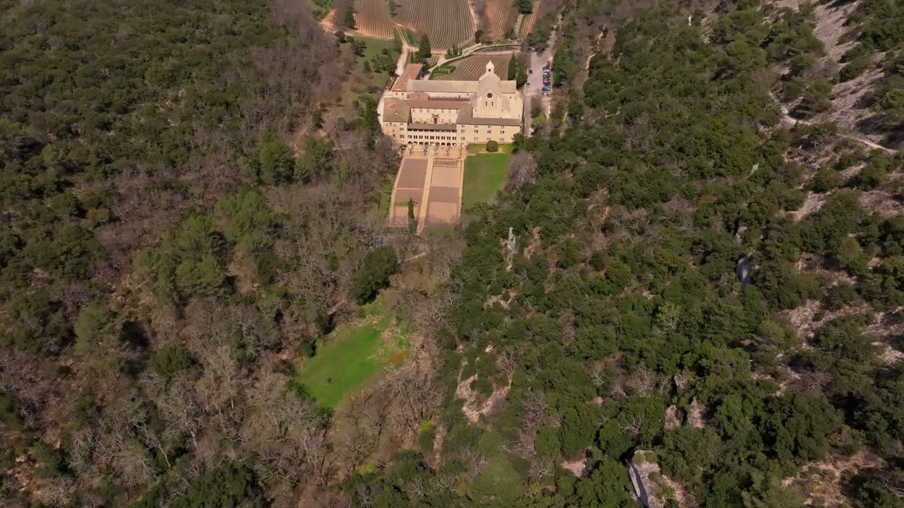 Vista aérea de la Abadía de Sénanque enmarcada por montañas en soledad espiritual