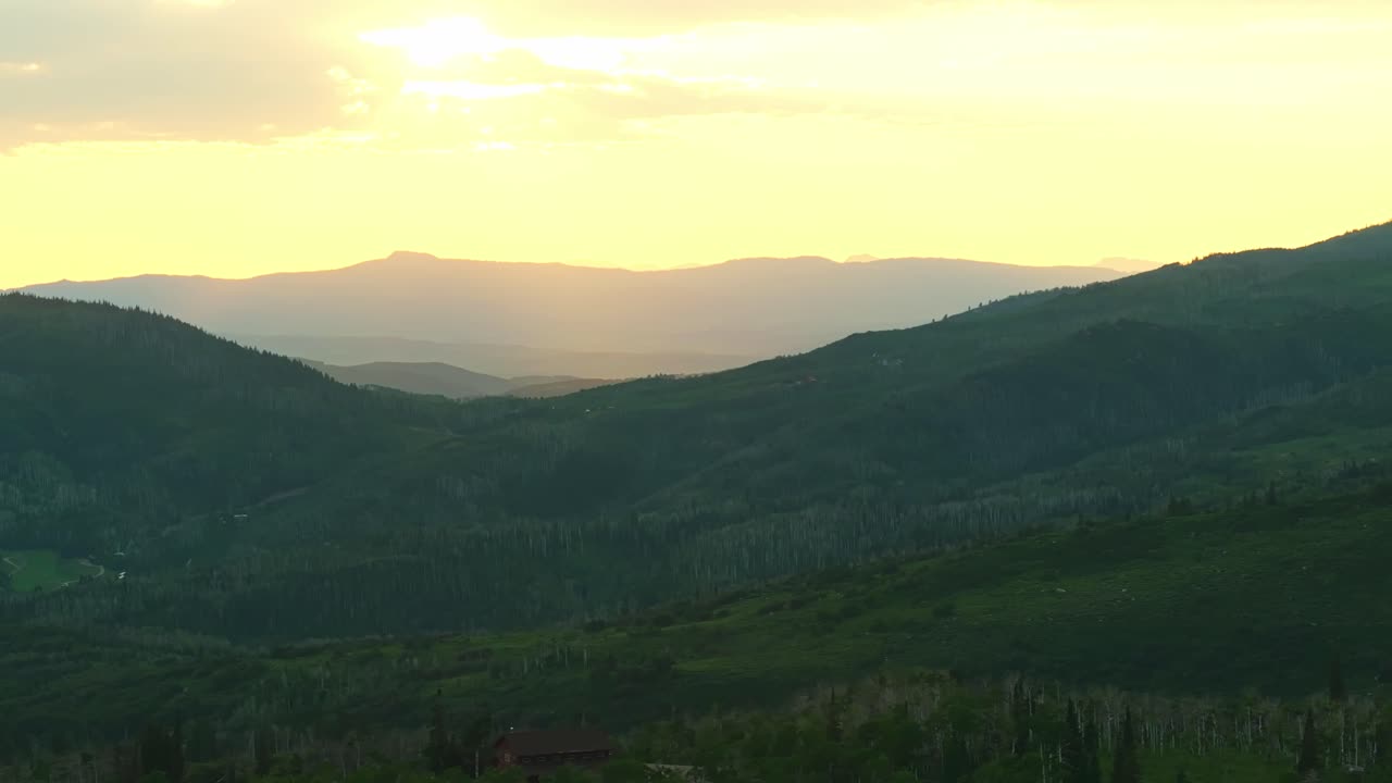 Sunset at Steamboat Springs hills with patches of green forest and open terrain, Colorado natural forest summer backdrop