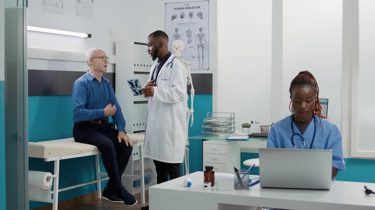 Doctor examining elderly patient's X-ray in clinic