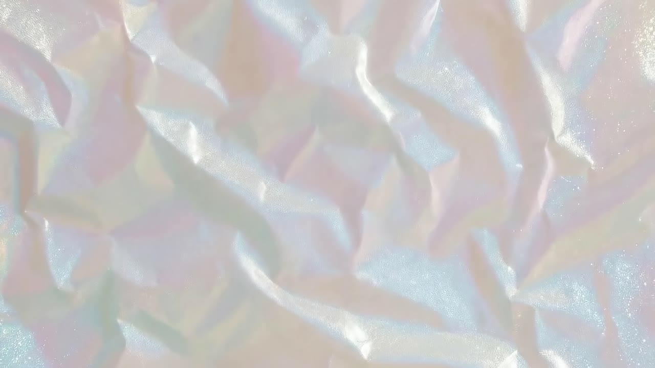 Vista aerea di una texture iridescente stropicciata, perfetta per uno sfondo video sognante.