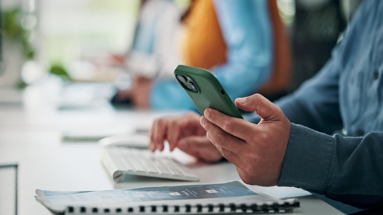 Person's Hands Holding Smartphone While Typing on Keyboard