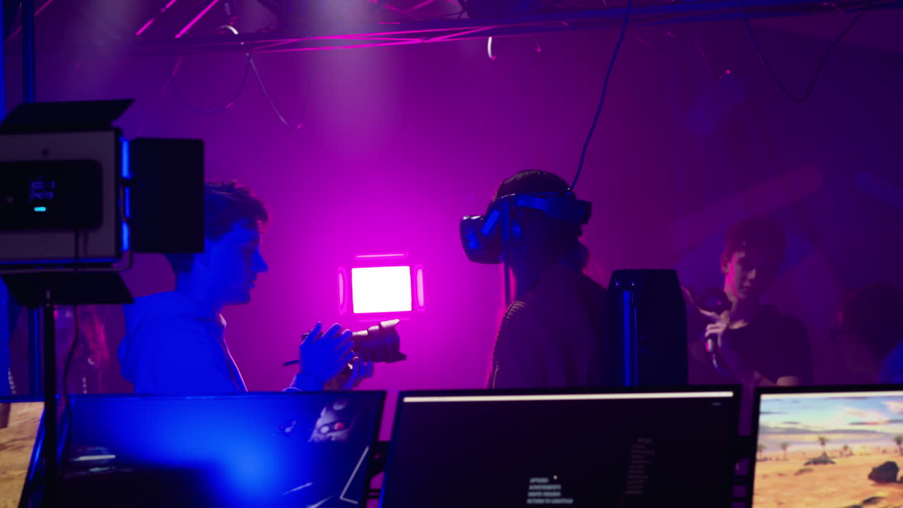 Camera man filming a woman playing with a Virtual Reality headset in a studio