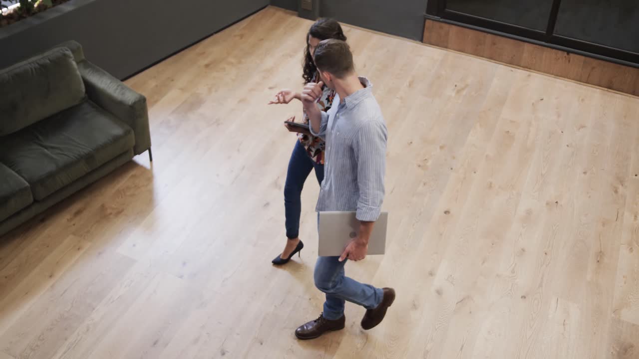 High angle view of diverse male and female colleagues in discussion in office foyer