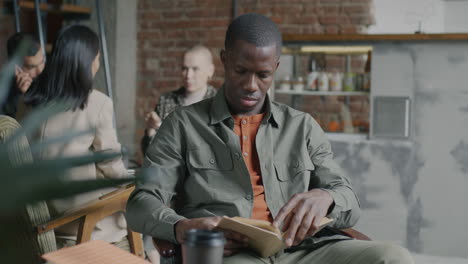 man reading in a busy cafe