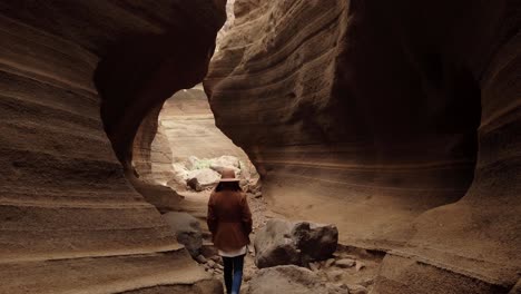 woman walking inside in ravine with big stones"