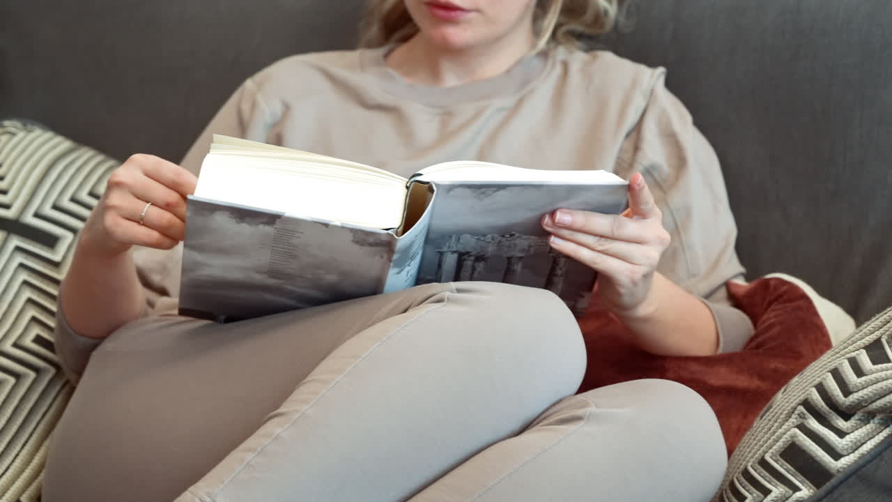 Woman reading a book at on the couch at home