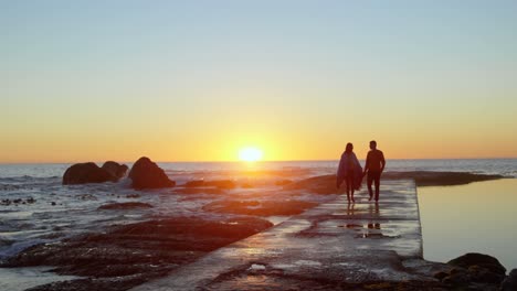 pareja caminando de la mano en el muelle durante el atardecer 4k